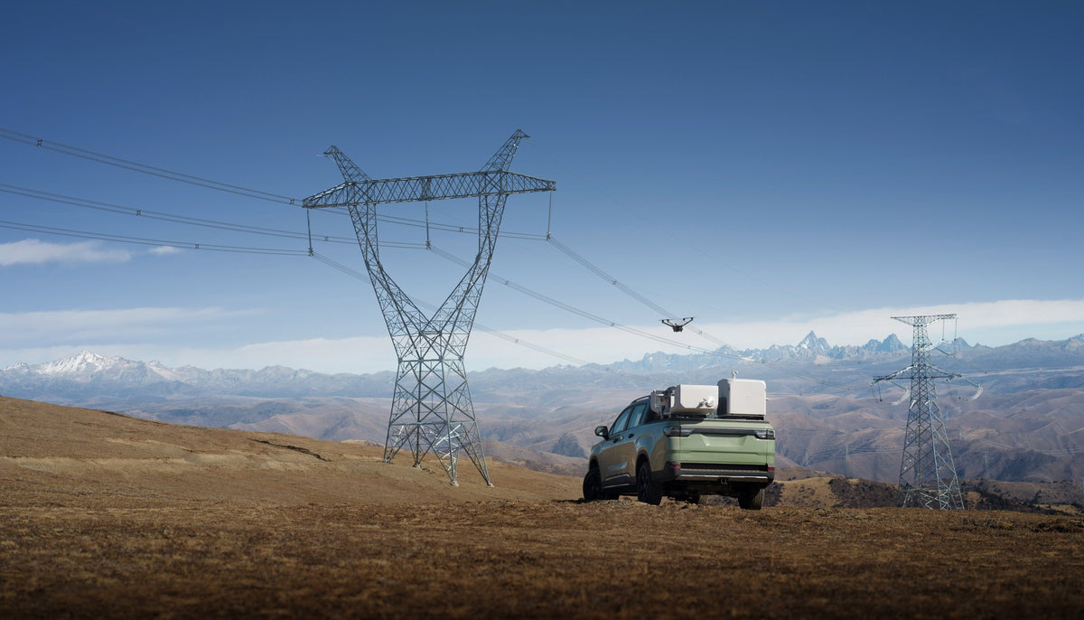 Vehicle-mounted DJI Dock 3 near a power pylon
